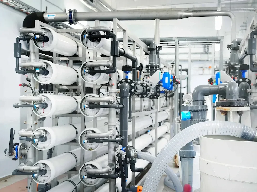 JARO-Industrial-Reverse-Osmosis-System-High-Pressure-Piping 10 High-pressure industrial reverse osmosis water treatment system featuring heavy-duty grey PVC and PP piping, secure flange connections, control valves, and multi-stage membrane pressure vessels in a manufacturing facility.