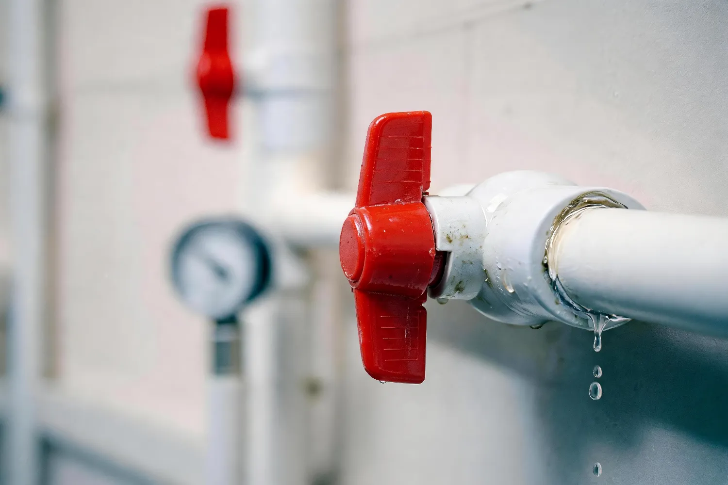 Water leaking from a pipe valve connection, illustrating a potential piping joint failure